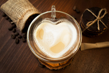 Glass cup in the shape of a heart and double glass. Cappuccino and chocolate cookies. Top view.