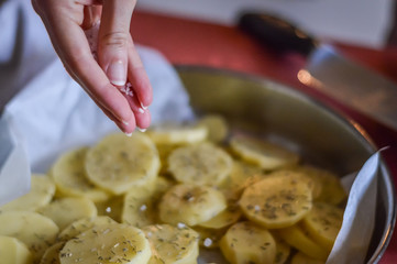 seasoning sliced potatoes before baking - close up
