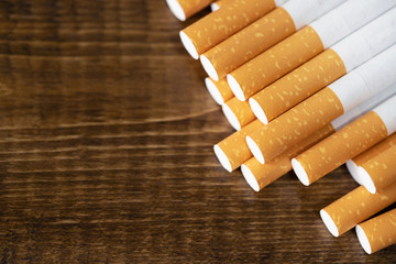 image of several commercially made cigarettes. pile cigarette on wooden dark background. or Non...