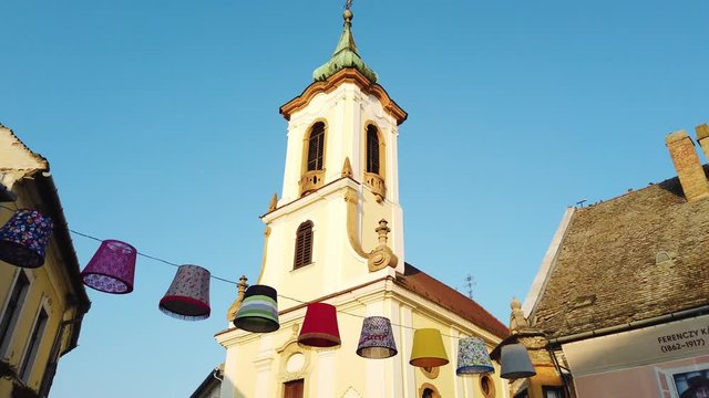 Church in old town of Szentendre with lamps in the foreground.