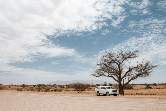 Large offroad vehicle stopped on the side of the road  for a picture while driving north on the C35 route to Twyfelfontein, Namibia, Africa