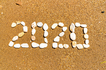 Lettering 2020 on sea sand