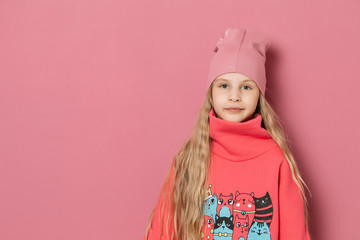 Little girl in pink clothes on a pink background