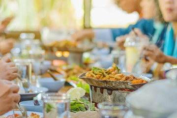 Group of female friends enjoy eating with acacia pennata omelette sour soup in fish shape hot pot in the restaurant. Selective focus.