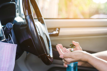 A woman wash her hands with blue alcohol gel to kill germs before driving car for hygiene purposes...