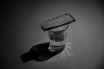 Glass of vodka with bread 2 black and white.