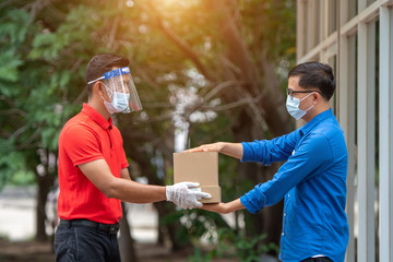 Delivery Staff holds a brown parcel box to send to customers.