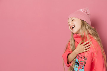 Little girl in pink clothes on a pink background