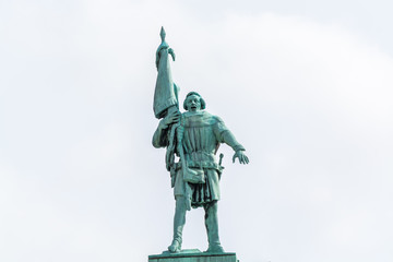 A bronze statue of a man holding a flag in the downtown of Stockholm, Sweden.