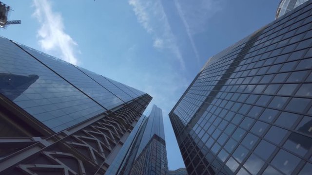 A low angle view of high raise office buildings under blue sky.