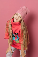 Little girl in pink clothes on a pink background