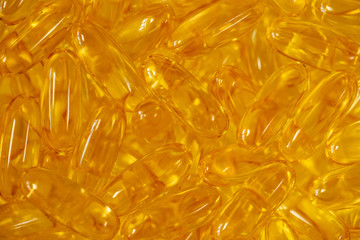 Closeup view macro photography of supplement organic vitamins in big transparent softgel capsules. Bright yellow shiny Omega 3 pills isolated on white background. Dietary supplement.