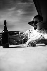 a man on the balcony is sitting at a table with a glass