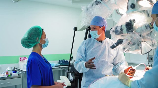 Doctor talking to woman during surgery. Doctor and patient discussing in operation room