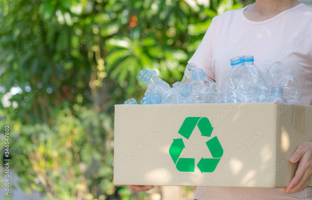 Wall mural woman hand holding box of garbage for recycle, plastic bottles garbage for recycling concept reuse. 