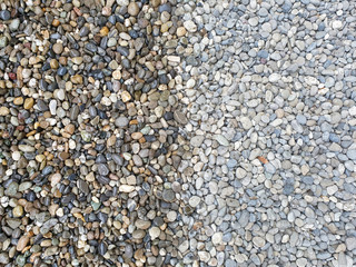 Colored, rounded and wet pebbles on the left and dry pebbles on the right where the color is not well emphasized as a background.