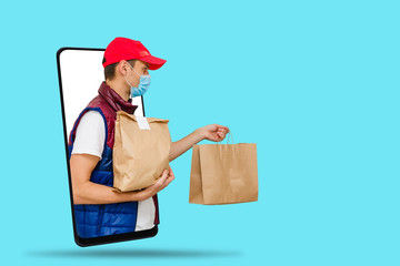 Delivery man in cap k t-shirt uniform face mask gloves hold cardboard box isolated on color background. Service quarantine pandemic coronavirus virus 2019-ncov concept