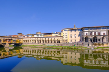 The famous Ponte Vecchio, the Old Bridge and city houses with reflections in the Arno River, Florence, Tuscany, Italy