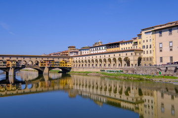 Fototapeta na wymiar The famous Ponte Vecchio, the Old Bridge and city houses with reflections in the Arno River, Florence, Tuscany, Italy