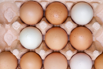 Cardboard tray of multi-coloured hens eggs and a couple of spaces