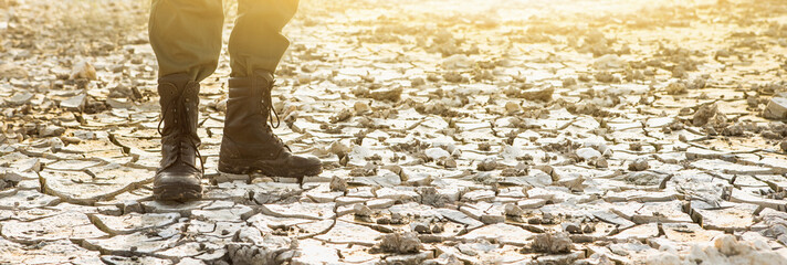 A man in boots stands in the desert