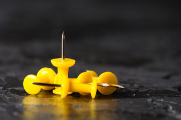 Yellow push pins on a dark background. Business concept, goal setting and achievement, team building