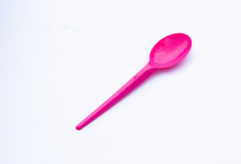 one vibrant pink plastic  spoon isolated on white