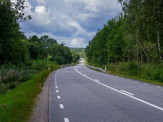 Fototapeta na wymiar A panorama of a country road through forest landscape in Sweden