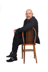 portrait of a man sitting on a chair looking at camera on  white background