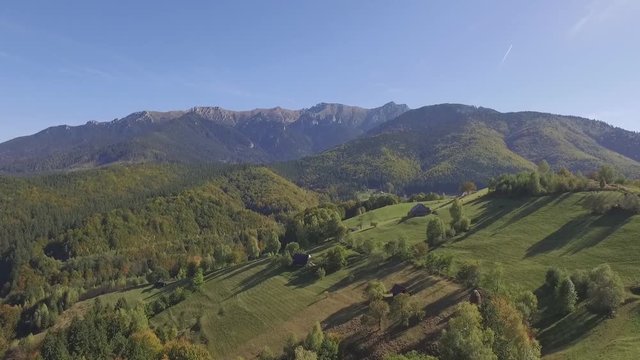 Aerial views of the scenic rural landscape surrounded by Carpathian Mountains and beautiful fresh green forests in the Brasov County, one of the most attractive tourist destinations in Romania
