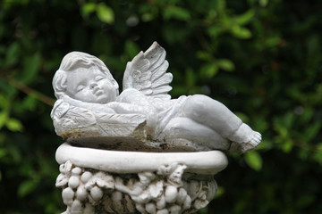 The white cupid sculpture decorated in the garden.
