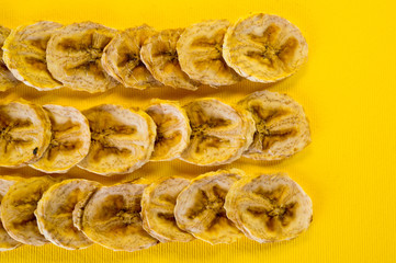 Dried banana chips, sliced in thin circles. Background for healthy and natural nutrition.
