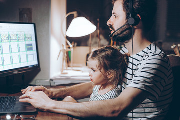 multi-tasking, freelance and fatherhood concept - working father with baby daughter and laptop...