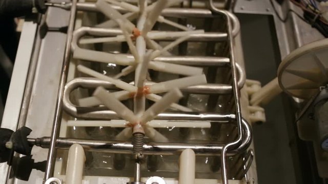 automatic ice-making plant close-up. Water from the pipe flows into the tray. The plastic agitator rotates. Zig-zag heat exchanger warm, dry