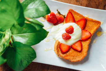Toast with Yogurt , strawberry and  honey  in  white plate on  wooden table, Breakfast baked