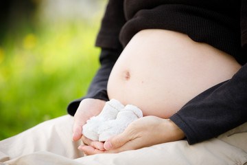 ソックスを手に持った妊婦さんのお腹クローズアップ