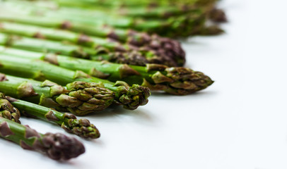 Bunch of fresh raw asparagus on white background, vegetarian concept. Green grass sparrowgrass sticks, food for veggie.