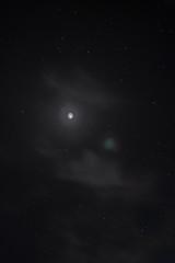 night sky with many stars and bright moon and clouds