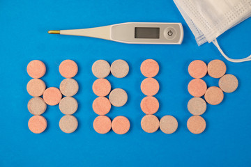Word LIFE written with pills, thermometer and medical protective mask on blue background. Stop Coronavirus concept.