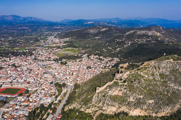 Obraz premium Old town of Nafplion in Greece view from above with tiled roofs, small port and bourtzi castle on the Mediterranean sea water