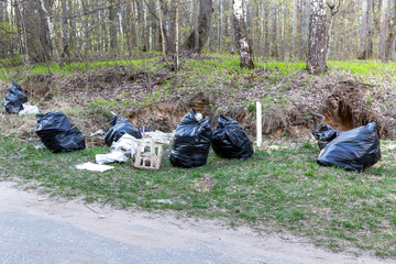 Collected garbage in plastic bags in the forest.