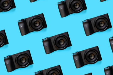 pattern of many digital mirrorless photo cameras on a blue background