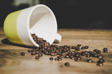 coffee beans in a white cup on an old wooden table