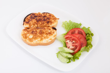 Grilled sandwiches with egg and cheese for breakfast. Decorated with vegetables in white plate