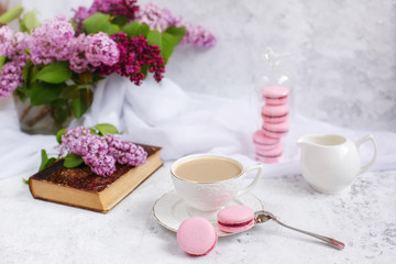 Obraz na płótnie Canvas postcard good morning. a Cup of coffee , a branch of lilac, macaroons, old books .
