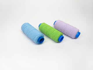 Colored sewing threads in pastel colors on a white background, top view