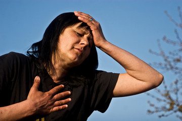 Woman holding her head. A young girl is having a headache. Symptoms A woman suffers a headache. Chest pain. Woman experiencing shortness of breath