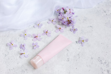 pink tube of cream on a grey background