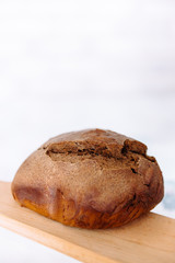 Fresh homemade crisp brown bread. Freshly baked bread on wooden cutting board. 