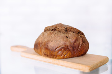 Fresh homemade crisp brown bread. Freshly baked bread on wooden cutting board. 
